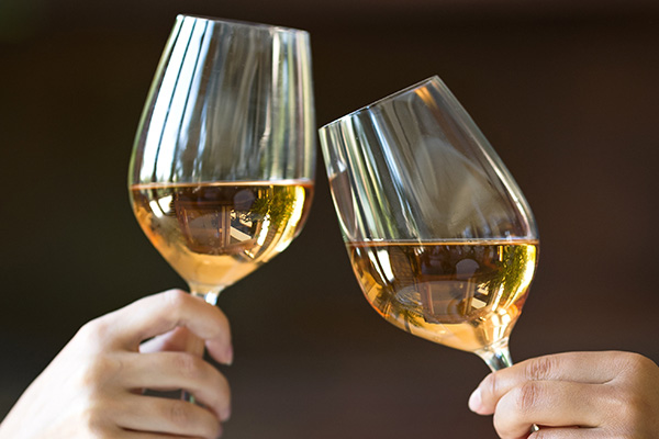 Two glasses of white wine in female hands